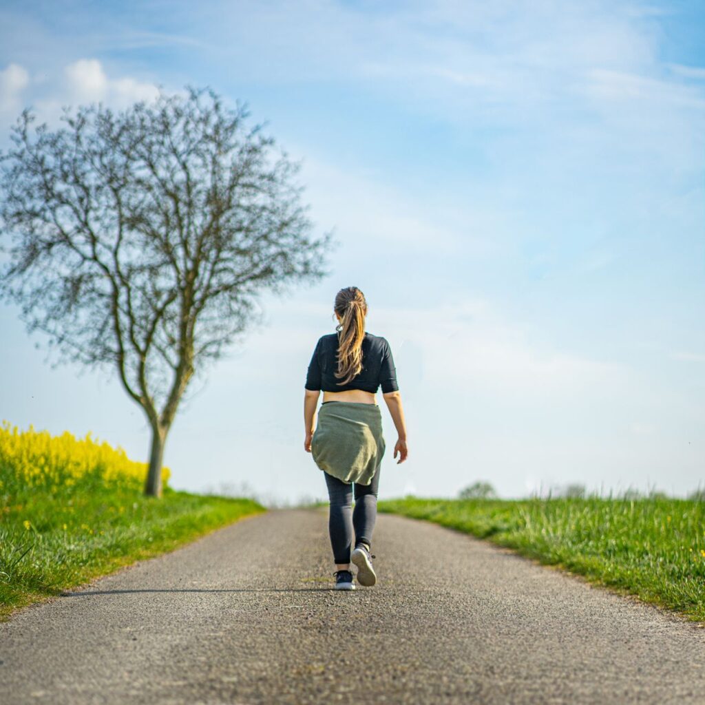 10 Science-Backed Everyday Wellness Habits That Actually Fit Your Life a woman walking on concrete pathway